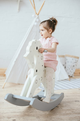 Photo of child riding a rocking horse